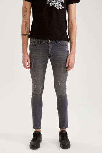 Супероблегающие джинсовые брюки с заниженной талией и узкими штанинами с рваными деталями