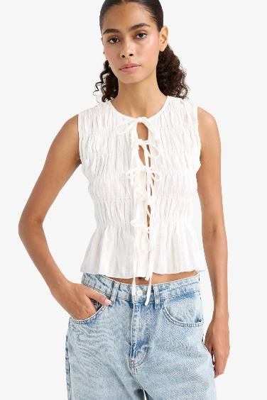 بلوزة كت سليم فيت برباط من الأمام وياخة مستديرة