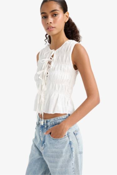 بلوزة كت سليم فيت برباط من الأمام وياخة مستديرة