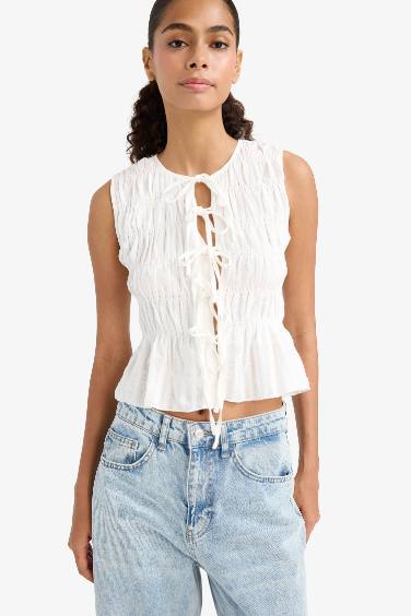 بلوزة كت سليم فيت برباط من الأمام وياخة مستديرة