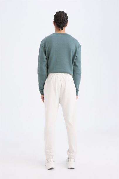 بنطلون بجامة رياضي قماش سكوبا سليم فيت برجل مطاطي من DeFactoFit