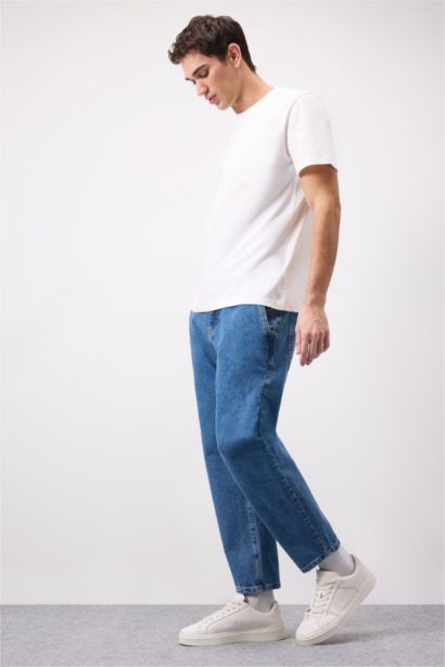 بنطلون جينز قصة مريحة فضفاضة ورجل عادي