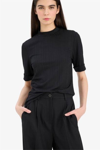 Регулярного кроя футболка с полуворотником-горлышком и короткими рукавами.