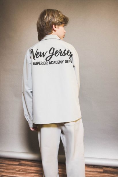 قميص كم طويل برسمة مدينة بياقة بولو