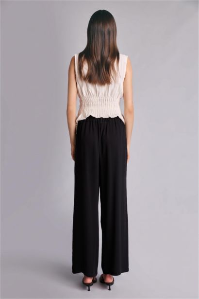 Pantalon noir large en viscose à taille haute et poches
