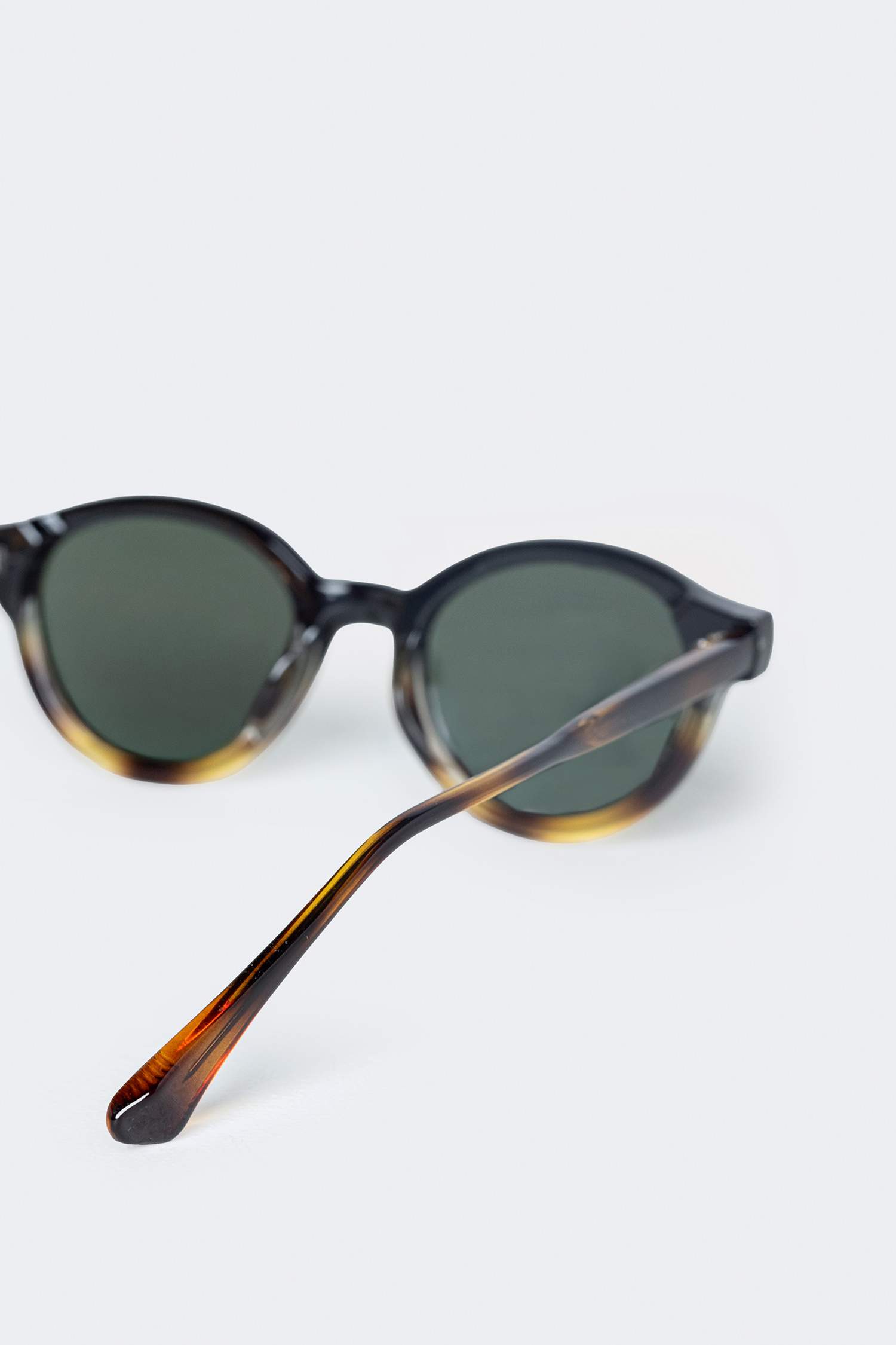 نظارات شمسية نسائية دائرية بإطار بلاستيكي أسود وعدسات سوداء