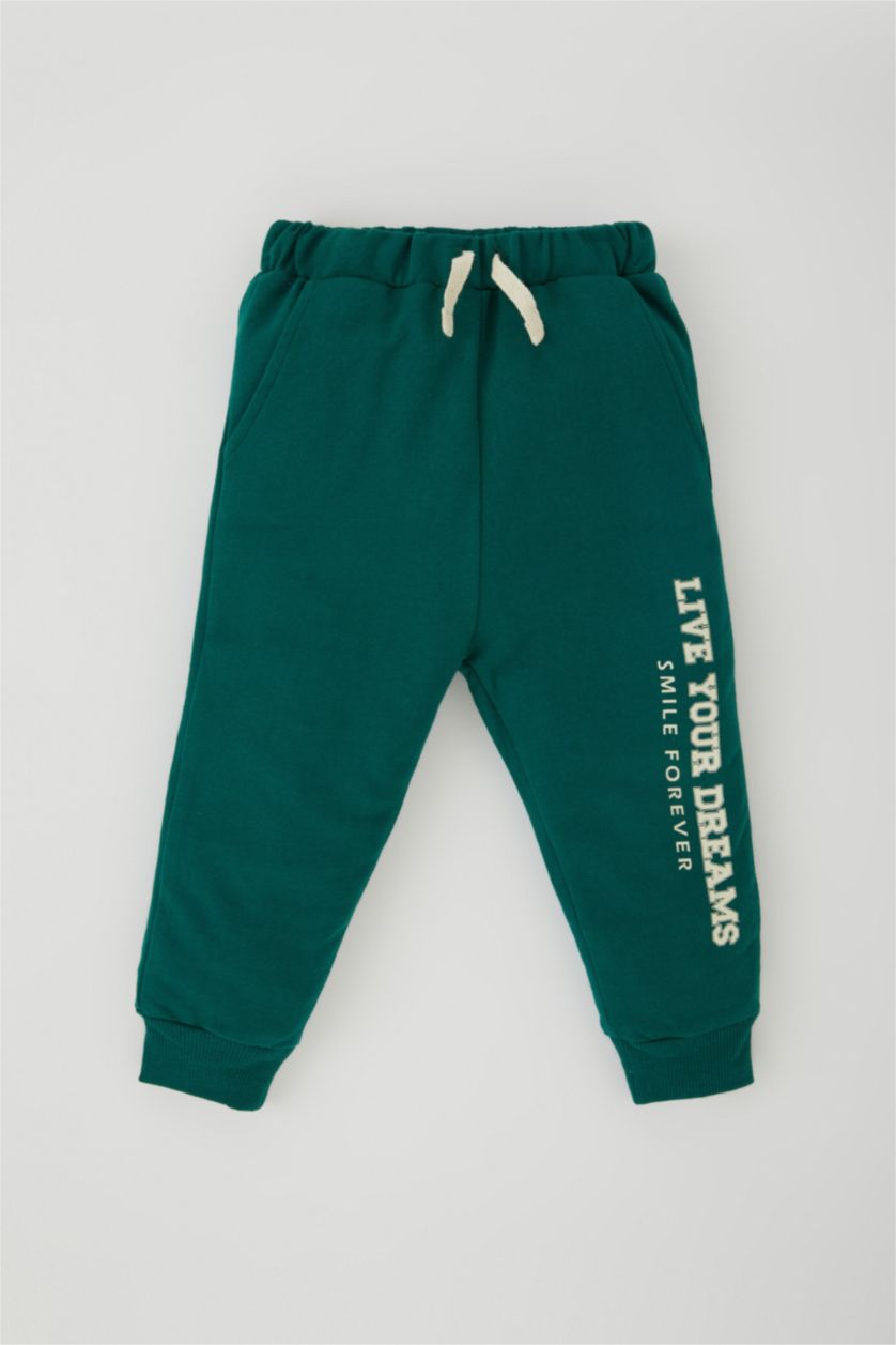 طفل صغير أخضر غامق بنطلون اولادي بطبعة شعار وقصة عادية