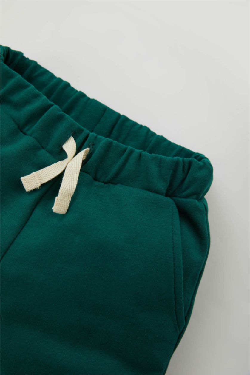 طفل صغير أخضر غامق بنطلون اولادي بطبعة شعار وقصة عادية