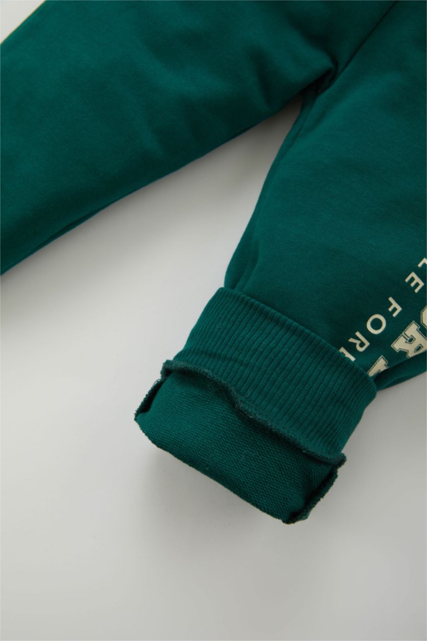 طفل صغير أخضر غامق بنطلون اولادي بطبعة شعار وقصة عادية