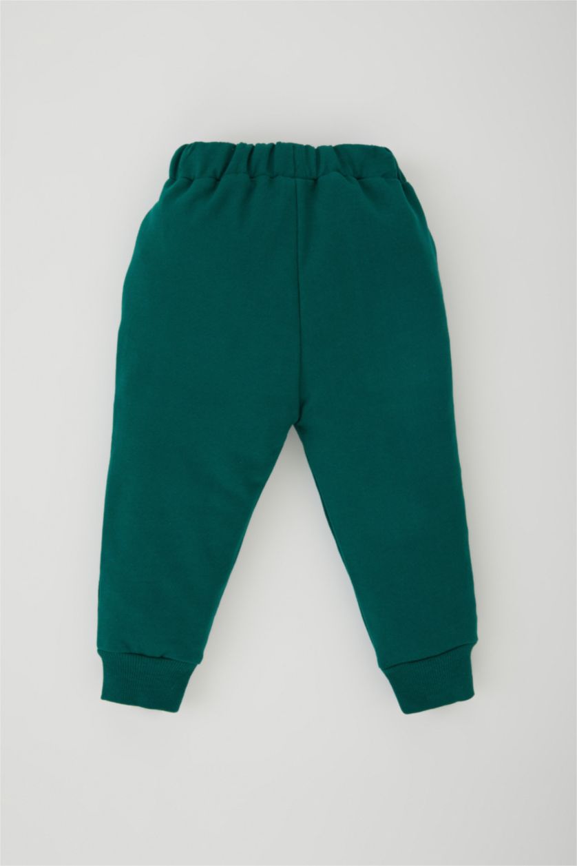 طفل صغير أخضر غامق بنطلون اولادي بطبعة شعار وقصة عادية