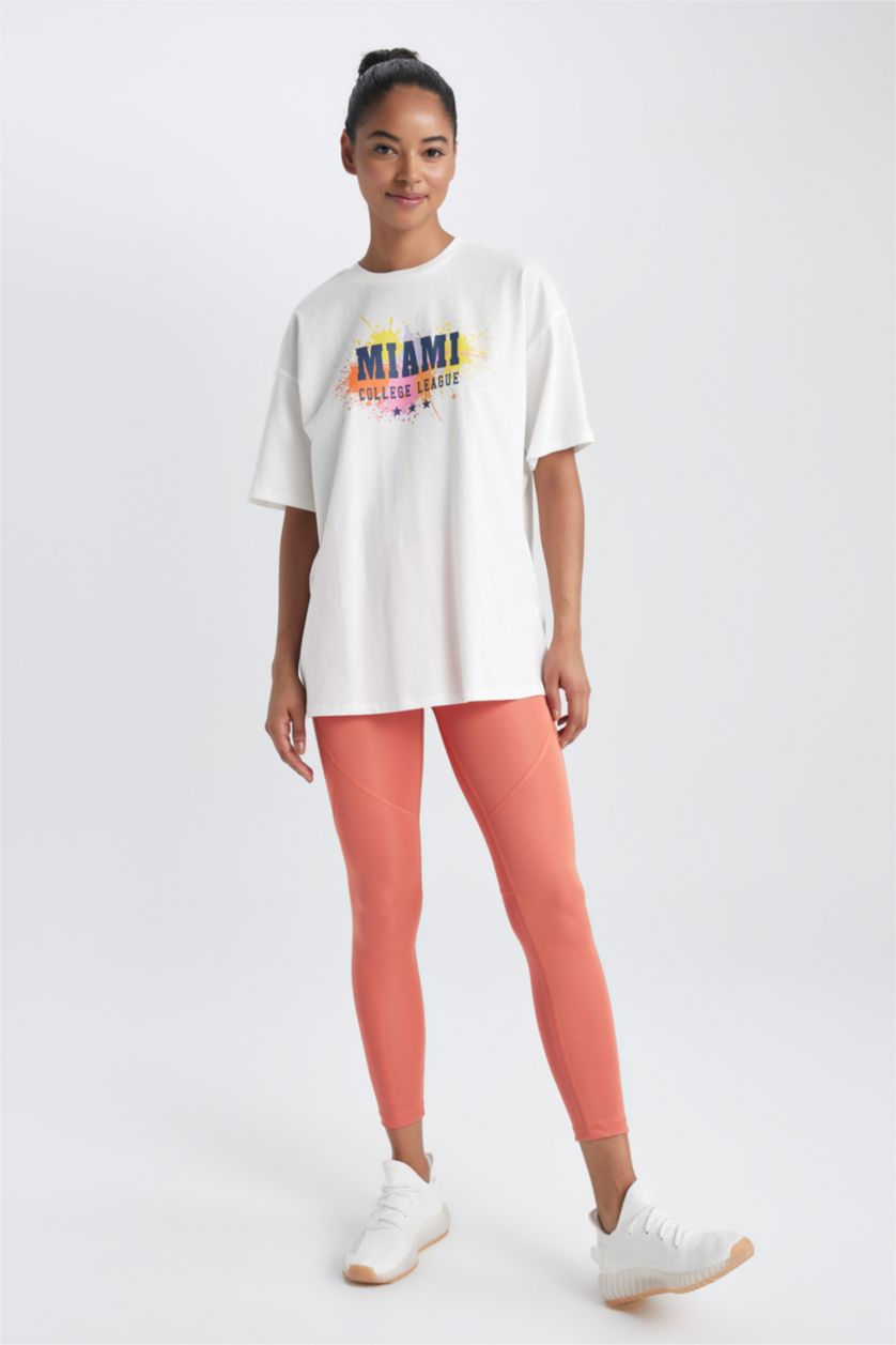 نساء بيج فاتح تيشيرت نص كم بطبعة شعار واسع برقبة مستديرة