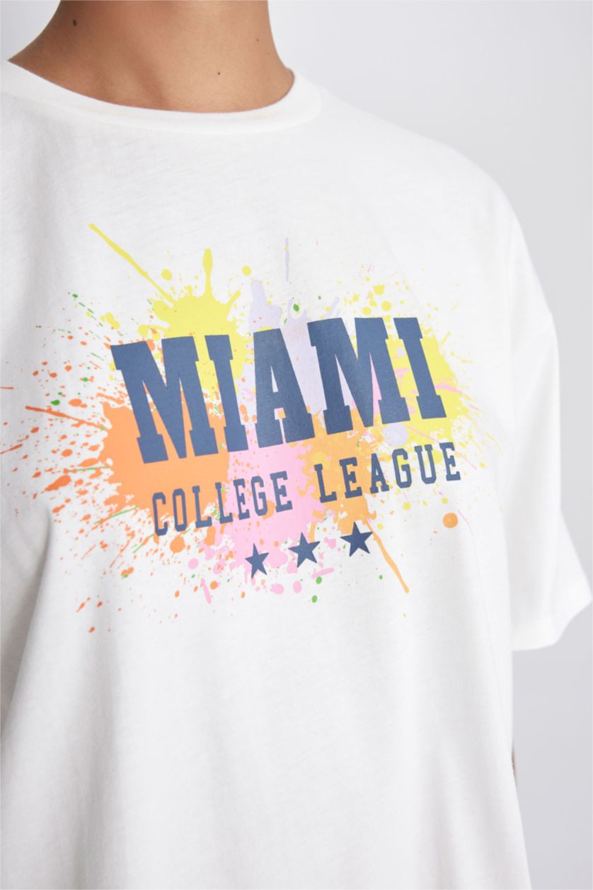 نساء بيج فاتح تيشيرت نص كم بطبعة شعار واسع برقبة مستديرة