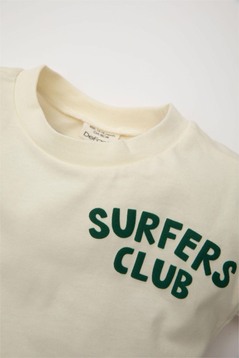 طفل صغير بيج فاتح تيشيرت نص ردن قصة عادية بطبعة شعار