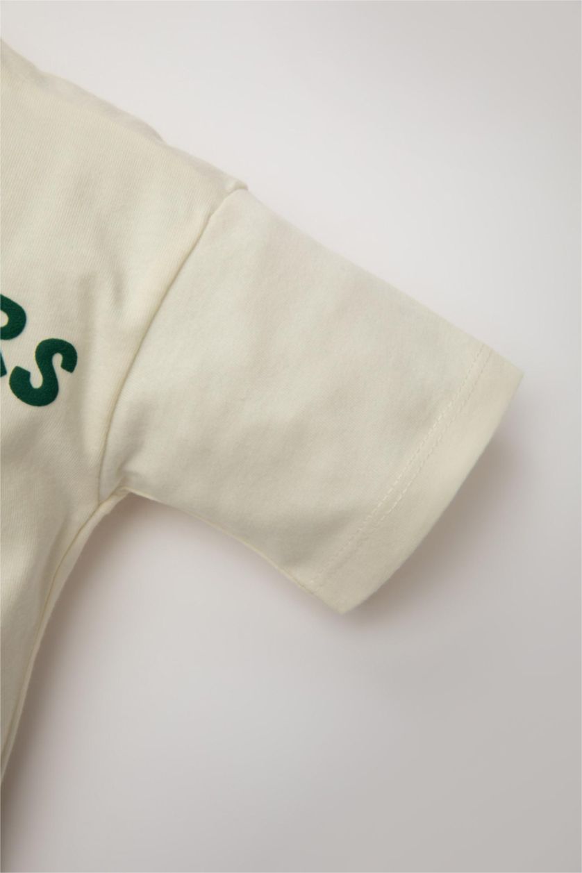 طفل صغير بيج فاتح تيشيرت نص ردن قصة عادية بطبعة شعار