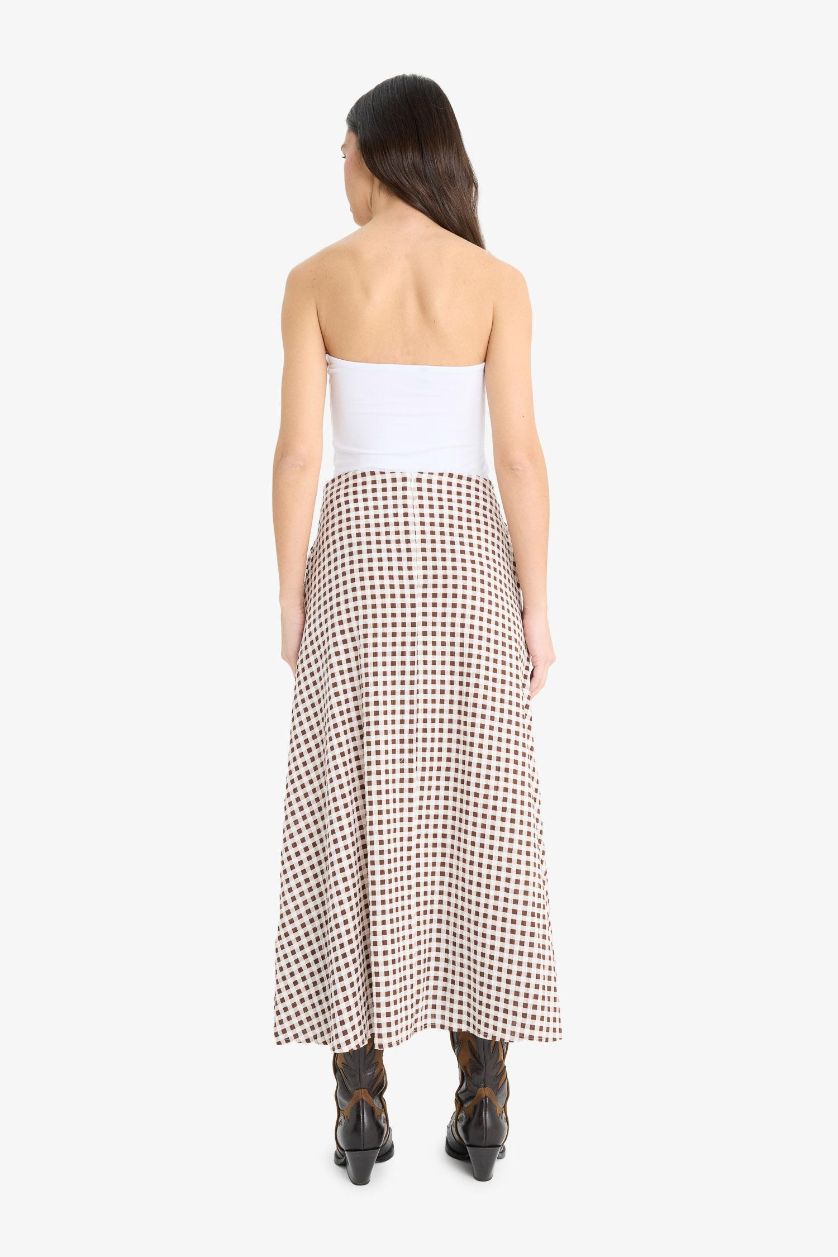 Әйелдерге Қоңыр басып шығарылған a сызығы максималды ұзындық Тоқылған юбка