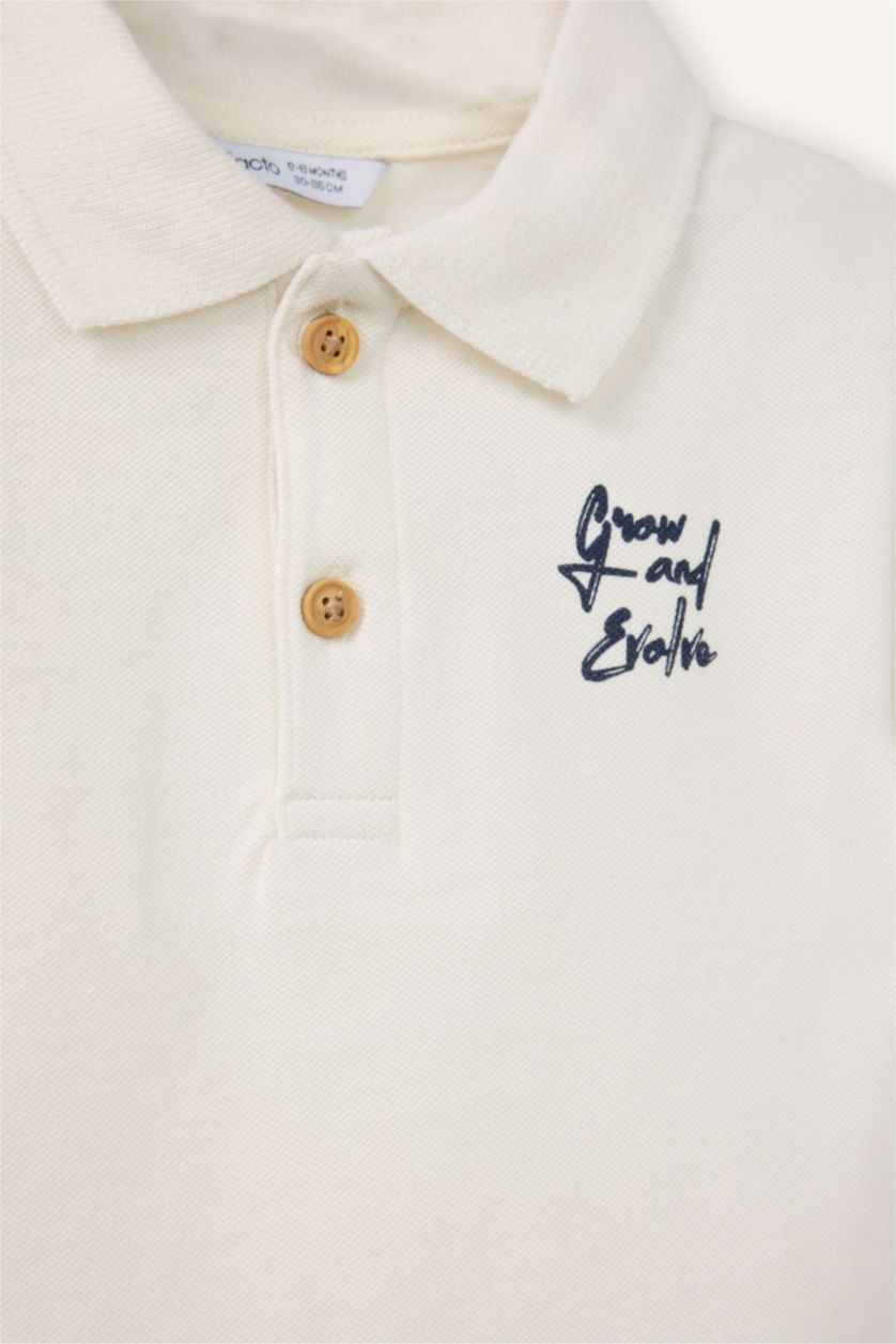 طفل صغير بيج فاتح تيشيرت بولو اولادي اوفر سايز نص كم بيكيه بطبعة شعار